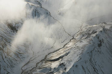 Ein Blick hinunter in das Tal von Landmannalaugar, wir sehen einige kleine Flüsse, die sich unter der Wolkendecke verbinden, Island. - AAEF04621