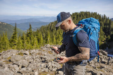 Hiker pairs his phone and GPS to navigate in the backcountry. - CAVF65751
