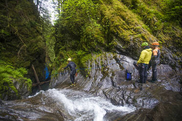 Man throws rope down waterfall before a rappel. - CAVF65777