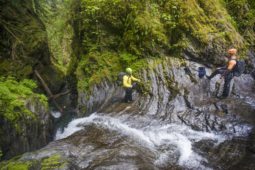 Two friends communicate before rappelling down canyon. - CAVF65780