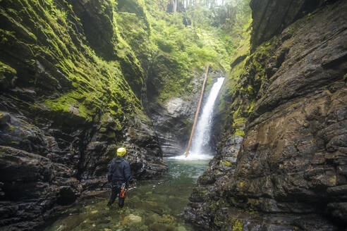 Wanderer blickt auf einen großen Wasserfall im Frost Creek Canyon. - CAVF65791