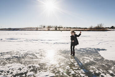Kleines Mädchen spielt auf gefrorenem See - CAVF65808