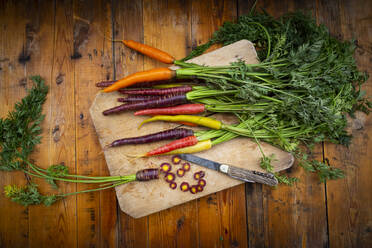 Penknife and fresh colorful carrots lying on cutting board - LVF08370