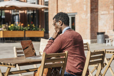 Young man using laptop in a coffee shop - VPIF01617