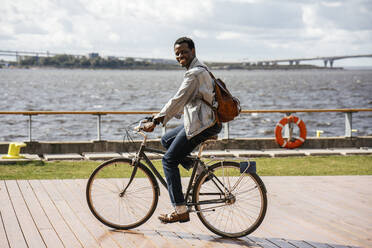 Junger Mann fährt Fahrrad am Meer - VPIF01681