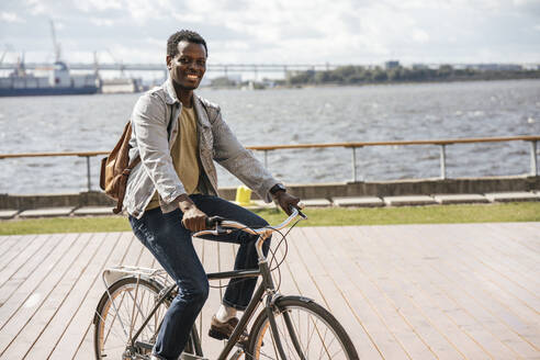 Junger Mann fährt Fahrrad am Meer - VPIF01682