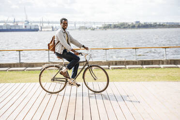 Junger Mann fährt Fahrrad am Meer - VPIF01685