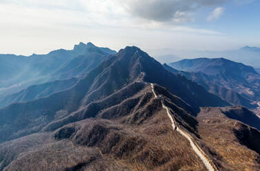 Aerial view of the Great Wall of China crossing mountain chain. - AAEF04755