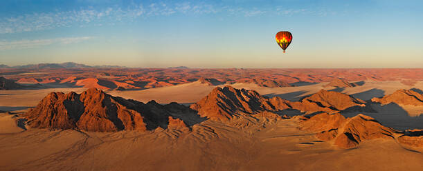 Luftaufnahme eines Heißluftballons, der über die Wüste Namibias fliegt. - AAEF05440