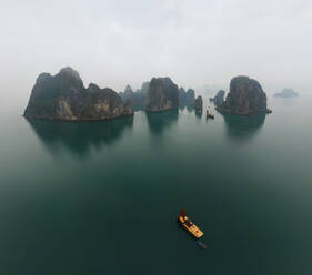 Luftaufnahme eines einzelnen Bootes in der Halong-Bucht an einem nebligen Tag, Vietnam - AAEF05590