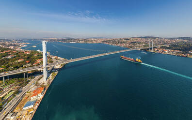 Aerial view of a shipping boat crossing under Bosphorus bridge, Istanbul, Turkey - AAEF05626