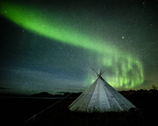 Aurora borealis (Northern Lights) over a traditional Lavvu, Senja, Norway, Scandinavia, Europe - RHPLF12300