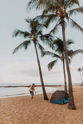 Scuba diver by tent on sandy beach, Princeville, Hawaii, US - ISF22526