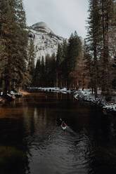 Mann fährt Kajak auf einem See, Yosemite Village, Kalifornien, Vereinigte Staaten - ISF22560