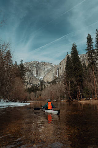 Mann fährt Kajak auf einem See, Yosemite Village, Kalifornien, Vereinigte Staaten, lizenzfreies Stockfoto