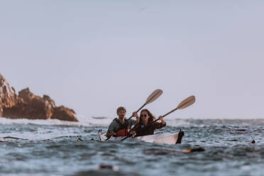 Freunde beim Kajakfahren im Meer, Big Sur, Kalifornien, Vereinigte Staaten - ISF22653