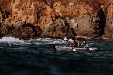 Friends kayaking in sea, Big Sur, California, United States - ISF22654