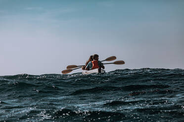 Friends kayaking in sea, Big Sur, California, United States - ISF22656