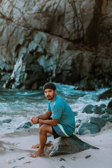 Mann entspannt sich am Strand, Big Sur, Kalifornien, Vereinigte Staaten - ISF22667