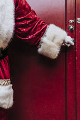 Der Weihnachtsmann öffnet mit seinen behandschuhten Händen die Tür und schließt sie - DAMF00200