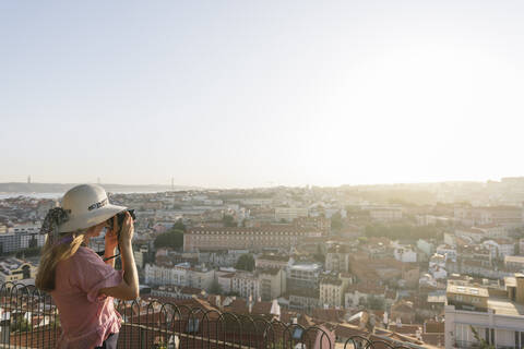 Frau beim Fotografieren des Stadtpanoramas, Lissabon, Portugal, lizenzfreies Stockfoto