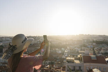 Frau, die ein Smartphone-Foto vom Stadtpanorama macht, Lissabon, Portugal - AHSF01005