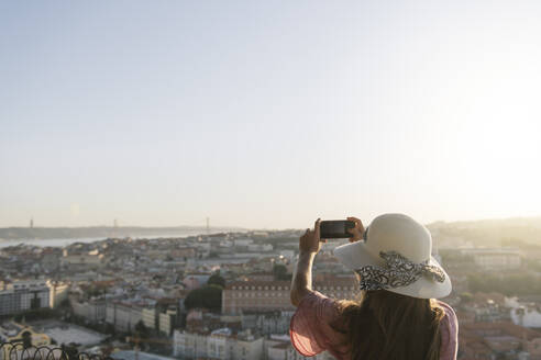 Woman taking a smartphone picture of the city panorama, Lisbon, Portugal - AHSF01006