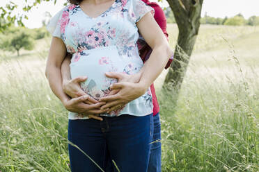 Schwangere Frau und Mann halten Babybauch - HMEF00660