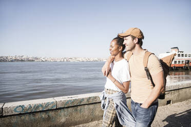 Young couple walking at the waterfront, Lisbon, Portugal - UUF19078