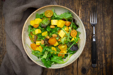 Bowl of salad with spinach, mango fruit, arugula and roasted peanuts - LVF08380