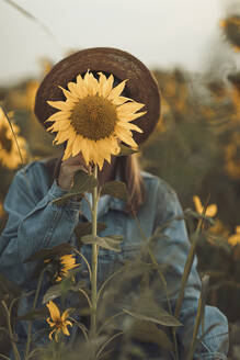 Junge Frau hinter einer Sonnenblume - OCAF00430