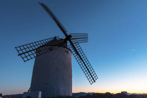 Spanien, Provinz Toledo, Consuegra, Alte Windmühle gegen den Himmel in der Abenddämmerung, lizenzfreies Stockfoto