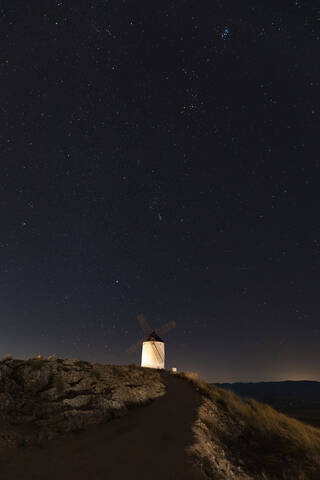 Spain, Province of Toledo, Consuegra, Starry sky over old windmill standing on top of hill at night stock photo