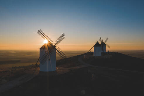 Spanien, Provinz Ciudad Real, Alcazar de San Juan, Alte Windmühlen auf einem Hügel bei Sonnenuntergang - WPEF02125