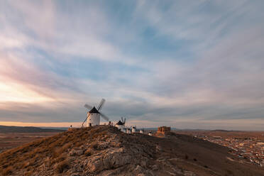Spain, Province of Toledo, Consuegra, Clouds over row of old windmills standing on top of hill - WPEF02133