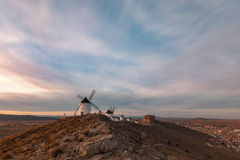 Spanien, Provinz Toledo, Consuegra, Wolken über einer Reihe von alten Windmühlen auf einem Hügel - WPEF02133