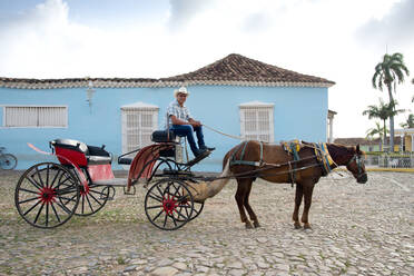 Cowboy wartet auf Reiter mit seinem Pferd und Kutsche auf der Plaza Mayor, Trinidad, UNESCO-Weltkulturerbe, Kuba, Westindien, Karibik, Mittelamerika - RHPLF12629