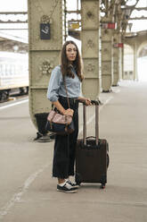 Young female traveller standing on train station - VPIF01725