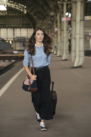 Junge weibliche Reisende auf dem Bahnhof, lizenzfreies Stockfoto
