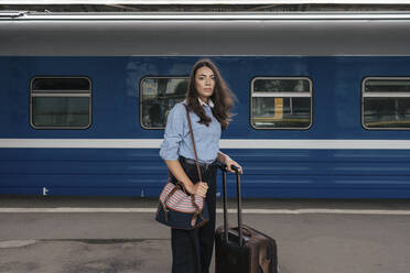 Junge weibliche Reisende wartet auf dem Bahnhof - VPIF01729
