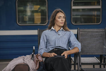Junge weibliche Reisende, die auf dem Bahnhof wartet und ein E-Book benutzt - VPIF01733