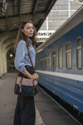 Young female traveller standing on the platform - VPIF01734