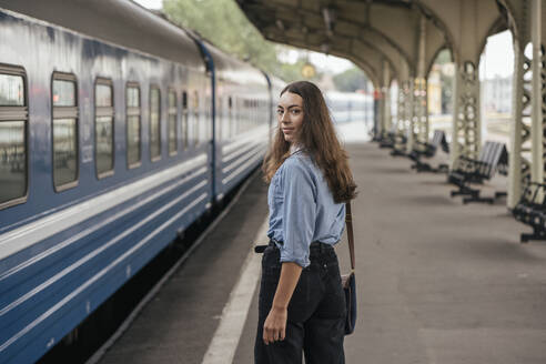 Junge weibliche Reisende auf dem Bahnhof - VPIF01736