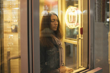 Young female traveller waiting and looking out of the window - VPIF01751