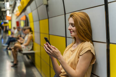 Frau benutzt Smartphone in U-Bahn-Station - AFVF04151