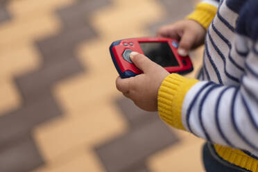 Kleiner Junge hält Spielzeug-Handy in den Händen, Nahaufnahme - VGF00323