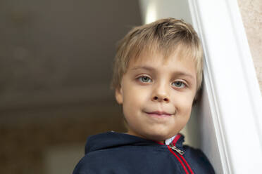 Porträt eines kleinen Jungen, der sich gegen eine Tür lehnt - VGF00327