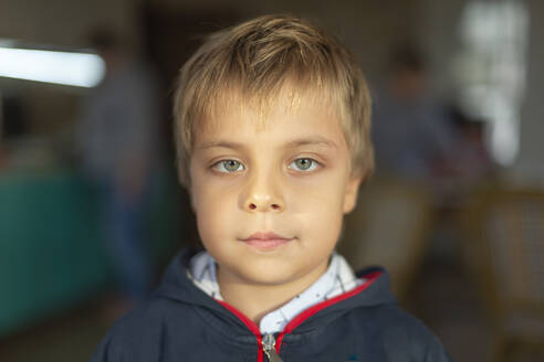 Porträt eines kleinen sitzenden Jungen mit grünen Augen - VGF00328