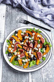 Plate of colorful autumnal salad with figs, feta cheese, arugula, blueberries and Hokkaido squash - SARF04389