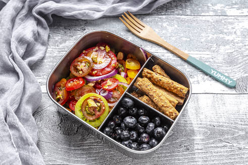 Metal box with tomato salad with red onion and pistachios, blueberries and biscuit sticks, wooden fork - SARF04393